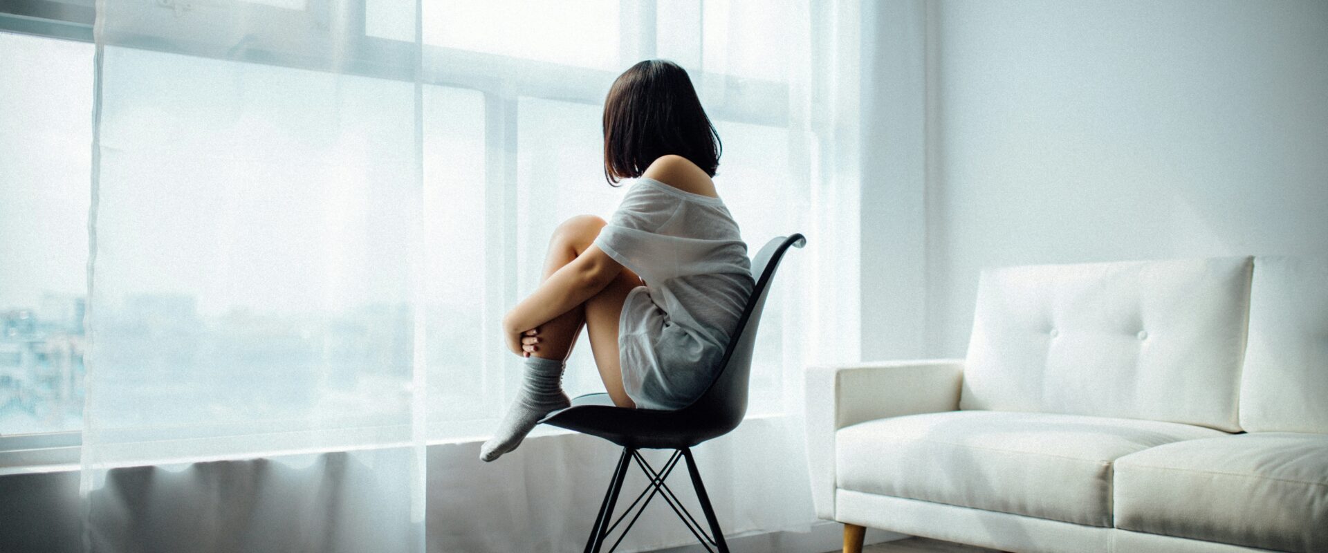 ženska gleda skozi okno